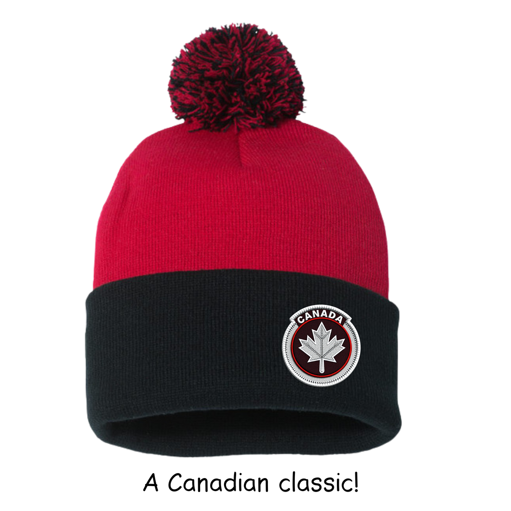Red and black beanie with a pom-pom and Canada maple leaf logo on a white background.
